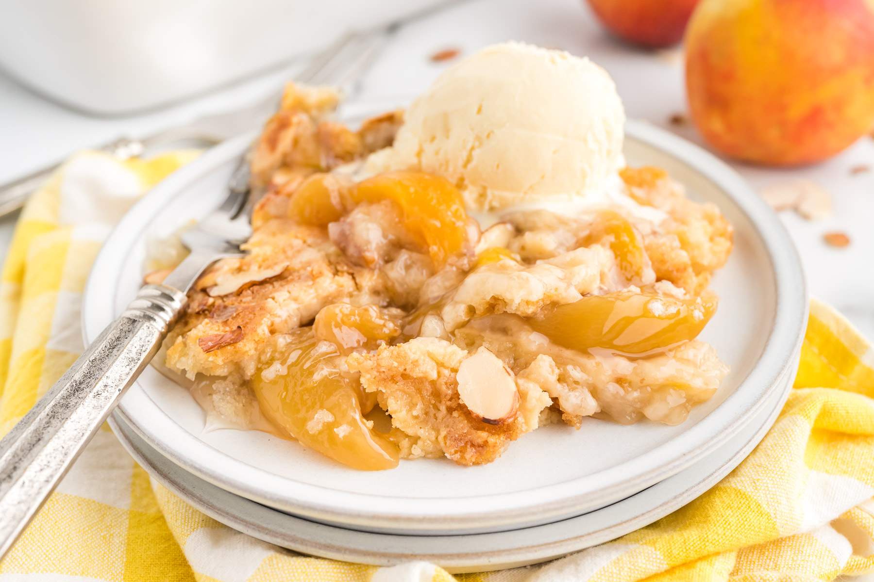 4 ingredient Peach Dump Cake on a plate with ice cream