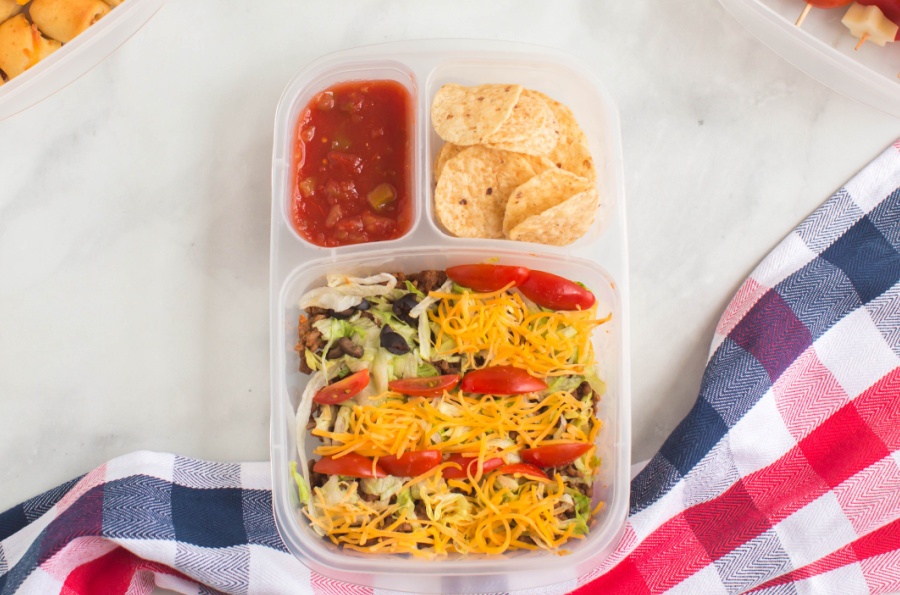 taco salad and chips and salsa in a lunchbox