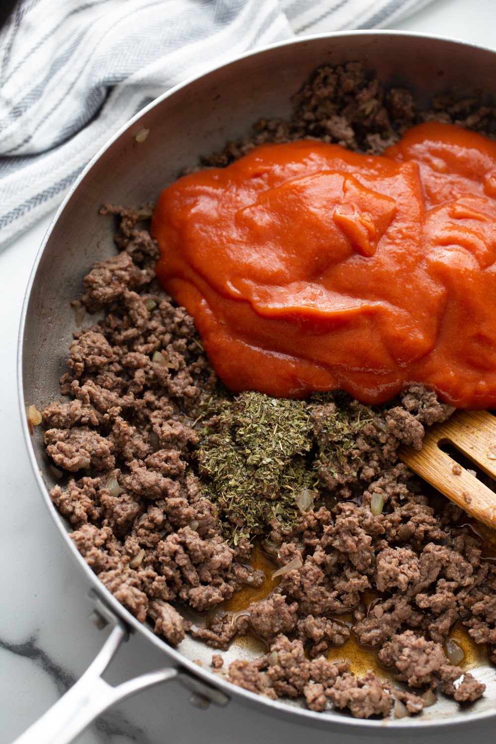 adding seasoning and tomato soup to pan