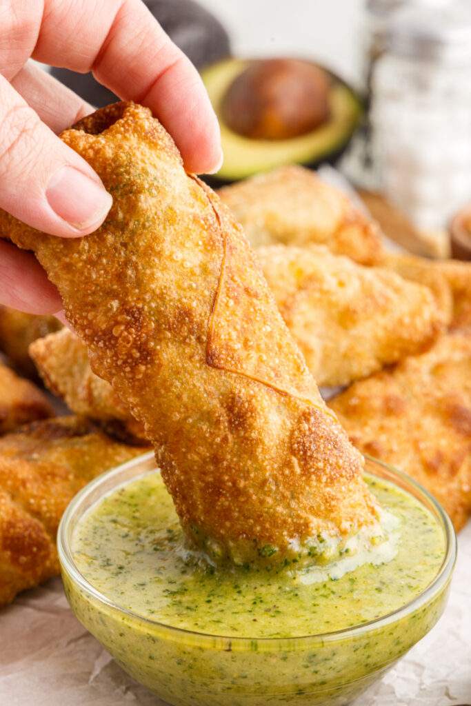 dipping Copycat Cheesecake Factory Avocado Egg Roll in dip