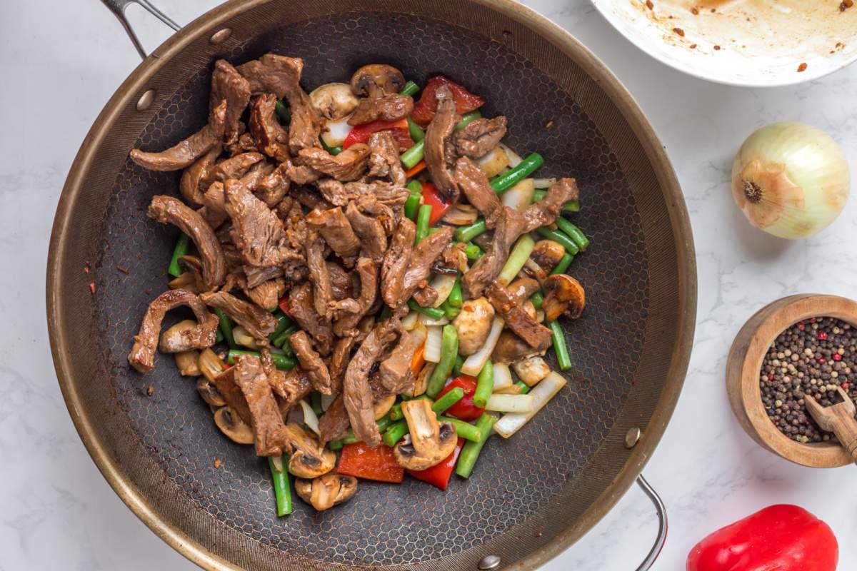 beef added into veggies in pan