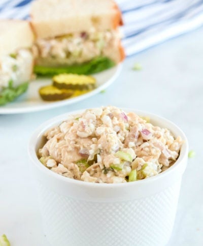 Cottage Cheese Tuna Salad in a small white bowl, with a sandwich in the background