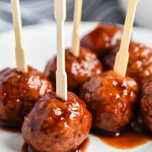 Crockpot Grape Jelly Meatballs on a plate with tooth picks