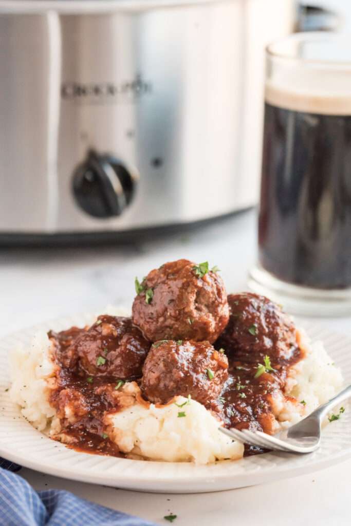 Crockpot Guinness Glazed Meatballs on a plate with mashed potatoes