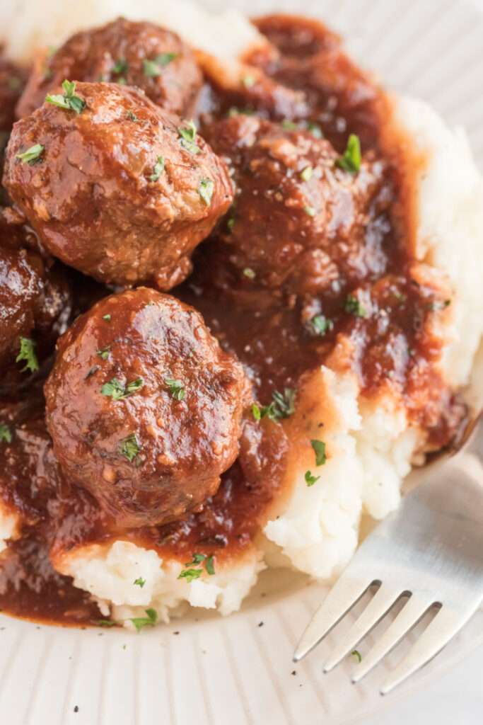 Crockpot Guinness Glazed Meatballs served over mashed potatoes