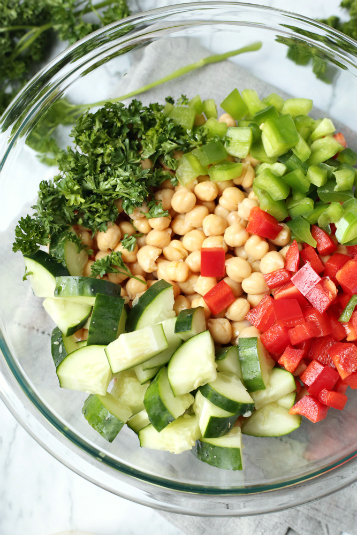 Cucumber Chickpea Salad - vegetables, beans and seasoning in glass bowl - Family Fresh Meals