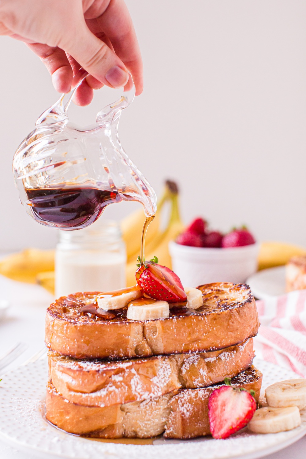 syrup being poured over Eggnog French Toast 