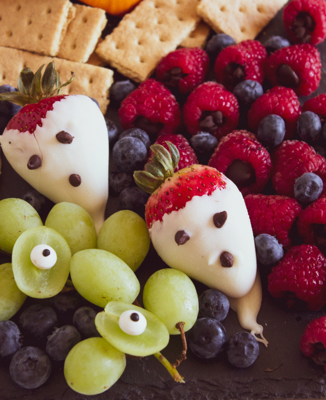 Halloween Appetizer Snack Board Idea - chocolate covered strawberries, grape eyes, raspberries and blueberries