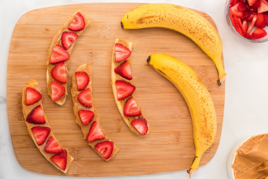 sliced bananas with nut butter on slice strawberries