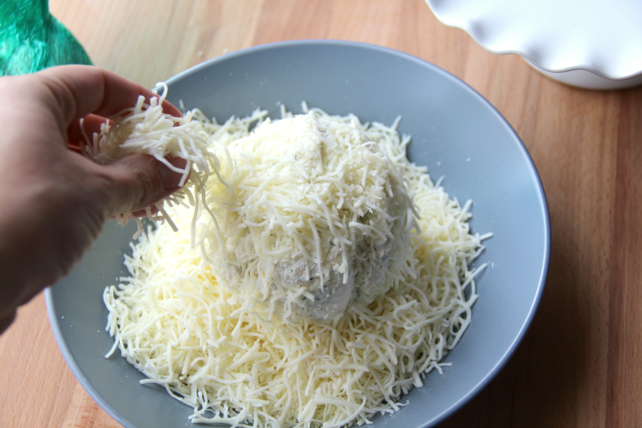 Placing shredded cheese around cheese ball