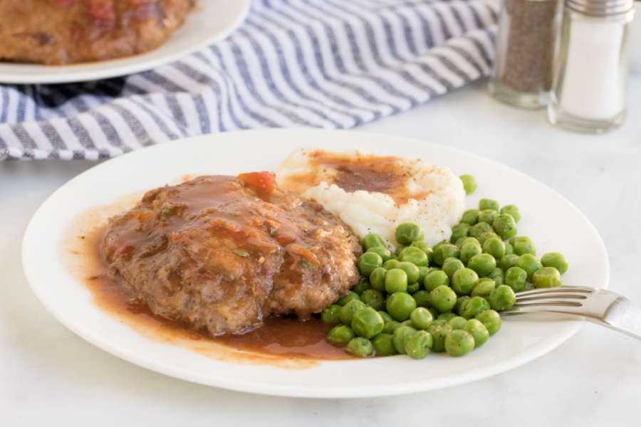 Crockpot Cubed Steak on a plate with peas and potatoes