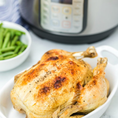 Instant Pot Dill Pickle Chicken Recipe - Cooked whole chicken in white baking dish