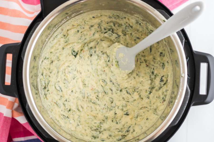 spinach artichoke dip being stirred