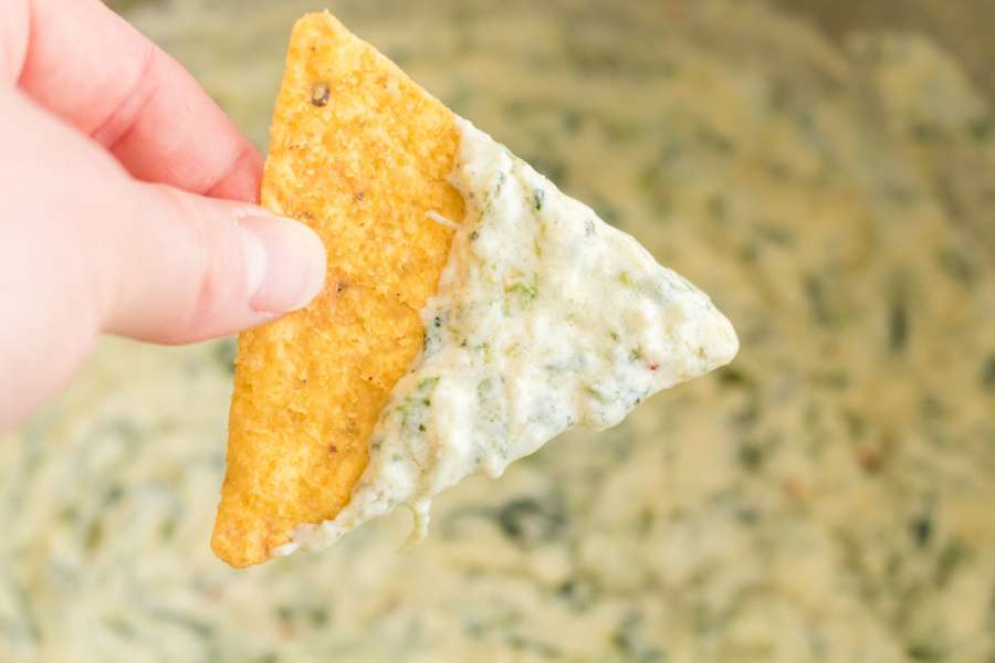 chip dipped in spinach artichoke dip 