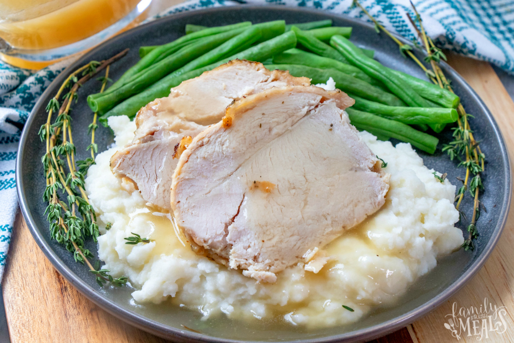 Instant Pot Turkey Breast - served on a blue plate with green beans and mashed potatoes