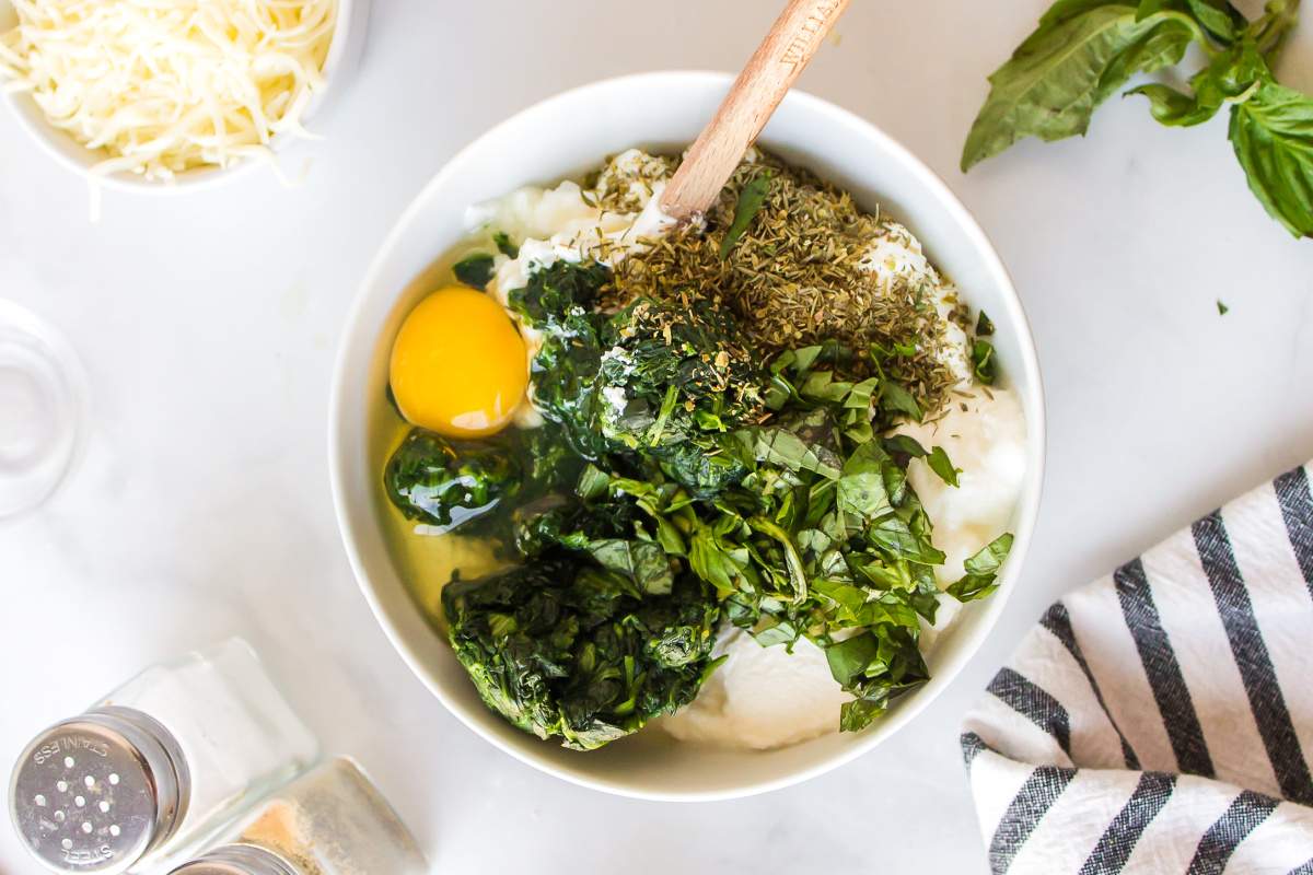  ricotta, egg, italian seasoning, fresh basil, salt, pepper, and sausage mixture in a mixing bowl