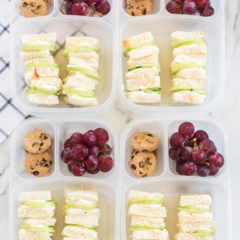 4 lunchboxes packed with Mini Cucumber Sandwiches, cookies and grapes