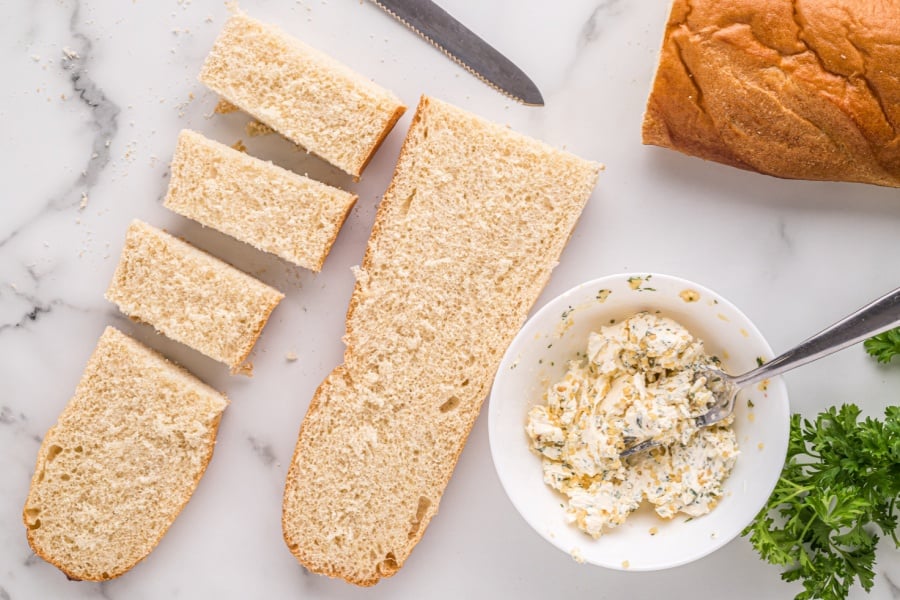 butter mixture in bowl with cut up bread on side