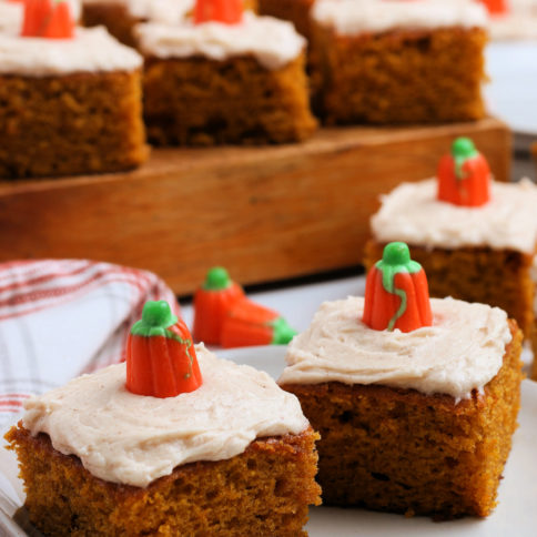 several pumpkin bars on a plate and on a wooden board