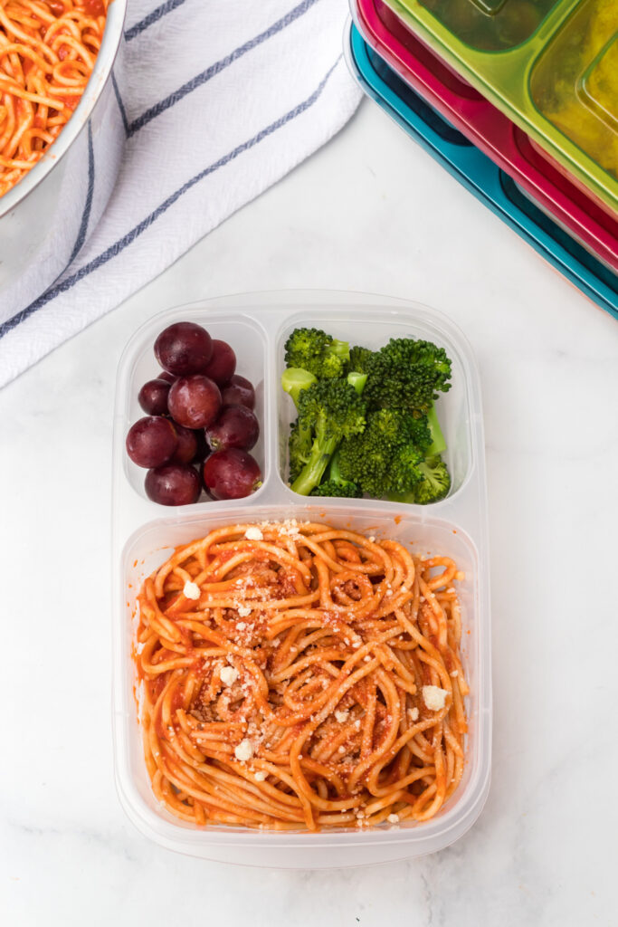 Spaghetti packed in a lunchbox with grapes and broccoli