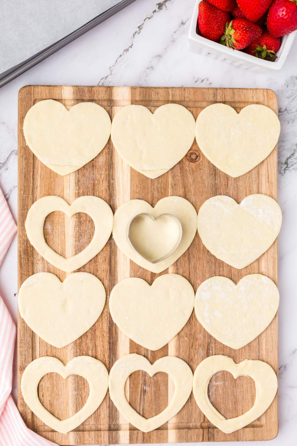 cutting smaller hearts from center of pastry hearts