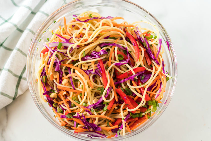 Thai Spaghetti Pasta Salad ingredients mixed together in a large mixing bowl