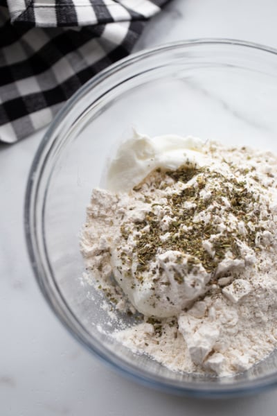 flour and Greek yogurt and seasoning in a glass mixing bowl