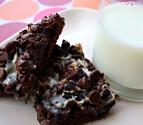 two cake bars on a white plate with a glass of milk