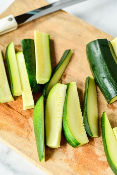 zucchini cut into spears on a cutting board